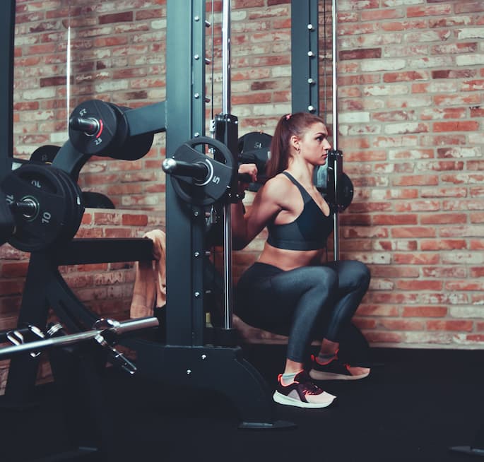 girl working out on a smith machine