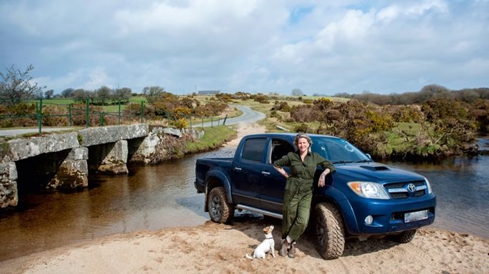 Lady standing next to a Toyota Hilux with her dog