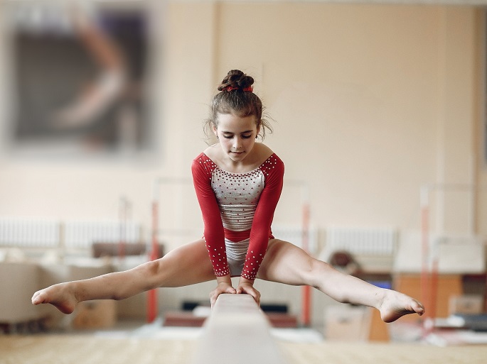 girl wearing a gymnastics leotard while practicing